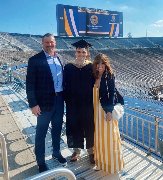 Cody Campbell with his parents in a graduation outfit.