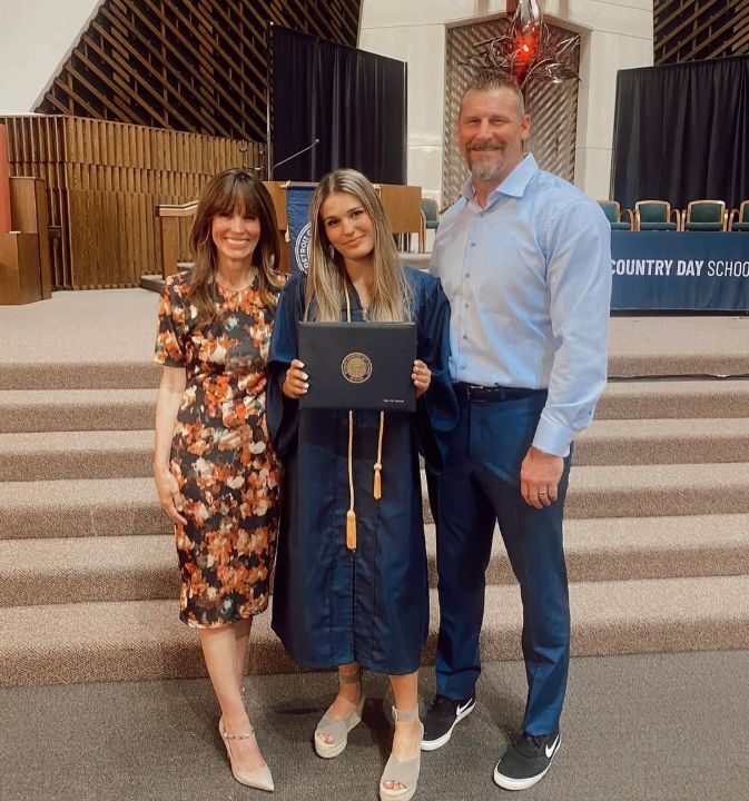 Piper Campbell standing with her parents in her graduation ceremony.